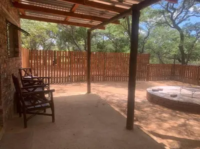 a patio with two chairs and a wooden fence at Vlakkieskraal FarmStay - Bosvark Cabin in Bela-Bela