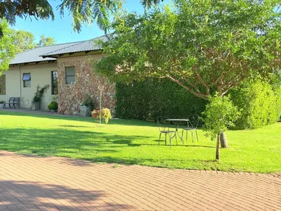 a house with a yard with a tree and a table at Private room Skyfall Country Estate in Polokwane