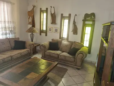 a living room with two couches and a table at Bosveld Kuier Hoofhuis in Bela-Bela