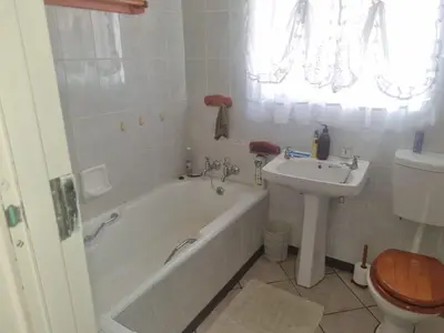 a bathroom with a tub and a sink and a toilet at Bosveld Kuier Hoofhuis in Bela-Bela