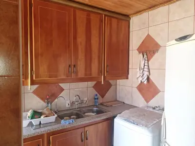 a kitchen with wooden cabinets and a sink at Bosveld Kuier Hoofhuis in Bela-Bela