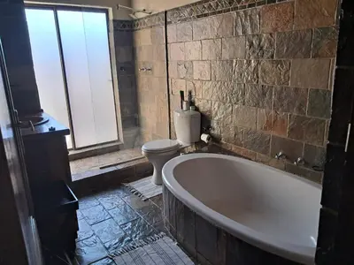 a bathroom with a bath tub and a toilet at Makhato Bush Lodge 6 in Bela-Bela