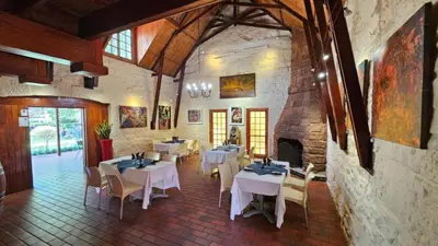 a restaurant with tables and chairs and a fireplace at Makhato Bush Lodge 6 in Bela-Bela