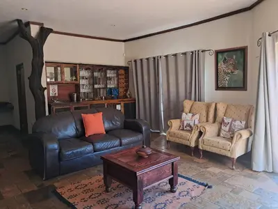 a living room with a leather couch and a coffee table at Makhato Bush Lodge 6 in Bela-Bela