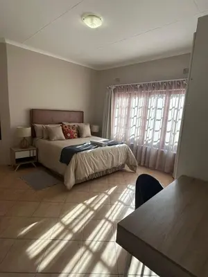 a bedroom with a bed and a large window at Winterfell Lephalale Lodge in Lephalale