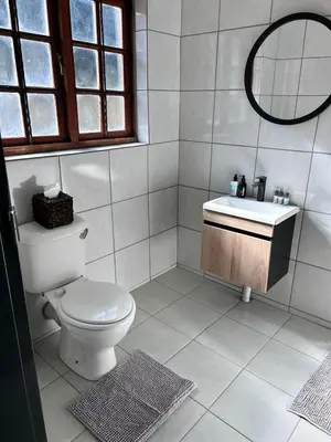 a white bathroom with a toilet and a sink at Winterfell Lephalale Lodge in Lephalale