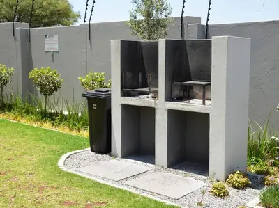 a concrete structure with a trash can in a yard at Elcaro Luxury Villas - The View in Midrand