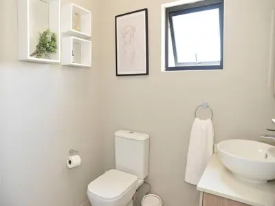 a white bathroom with a toilet and a sink at Elcaro Luxury Villas - The View in Midrand