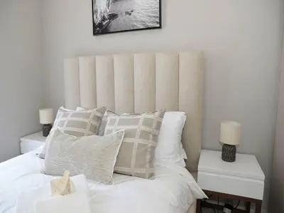 a bedroom with a white bed with two night stands and two lamps at Elcaro Luxury Villas - The View in Midrand