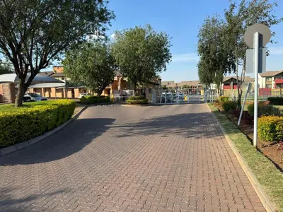 a brick road with trees and a fence at ATHA AirBnB in Midrand