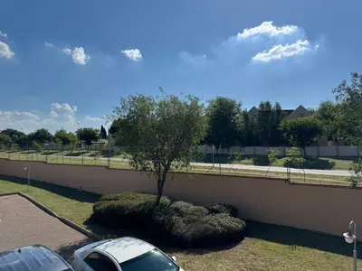 a car parked next to a wall with a tree at ATHA AirBnB in Midrand