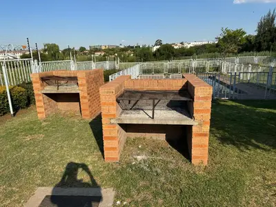 two benches in a park with a fence at ATHA AirBnB in Midrand