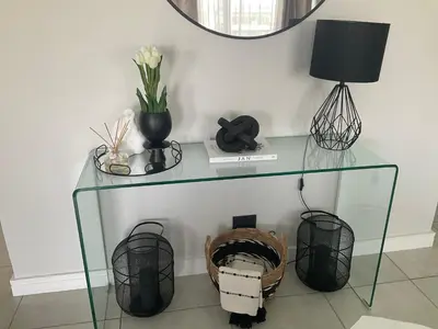 a glass table with a lamp and a basket at The Blyde Stylish Homes in Pretoria