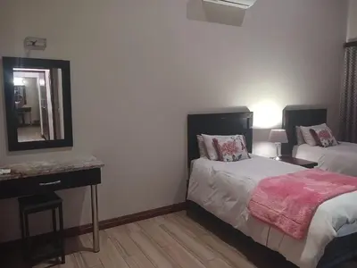 a bedroom with a bed and a mirror and a desk at Zebula Golf and Wildlife Estate - Moi Signature Exclusive Leisure Villas in Mabula