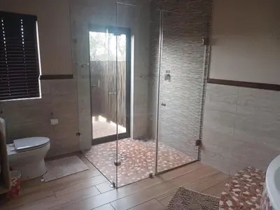 a bathroom with a glass shower with a toilet at Zebula Golf and Wildlife Estate - Moi Signature Exclusive Leisure Villas in Mabula
