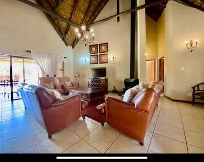 a living room with leather furniture and a table at Zebula Golf and Wildlife Estate - Moi Signature Exclusive Leisure Villas in Mabula