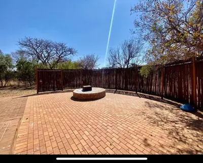 a brick patio with a fence and a bench at Zebula Golf and Wildlife Estate - Moi Signature Exclusive Leisure Villas in Mabula