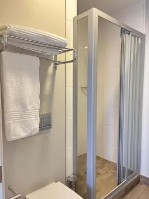 a bathroom with a toilet and a glass shower at REGENCY APARTMENT HOTEL-ST@Y in Pretoria