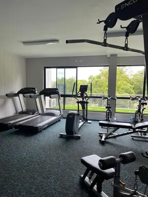 a gym with several treadmills and machines in a room at REGENCY APARTMENT HOTEL-ST@Y in Pretoria