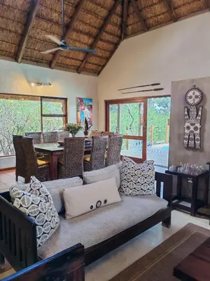 a living room with a couch and a table with a laptop at Sausage Tree Safari Camp in Balule Game Reserve