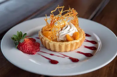 a dessert on a white plate with a strawberry at Sausage Tree Safari Camp in Balule Game Reserve