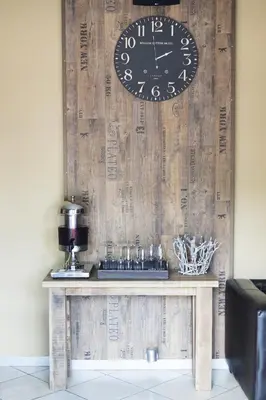 a clock on a wall next to a table at Ivory Lodge Bendor in Polokwane
