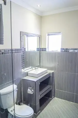 a bathroom with a toilet and a sink and a shower at Ivory Lodge Bendor in Polokwane