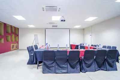 a conference room with a long table and blue chairs at Ivory Lodge Bendor in Polokwane