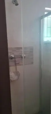 a glass shower door in a bathroom with a window at Streetview Suites in Polokwane