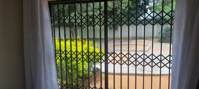 a gate with a view of a garden through a window at Streetview Suites in Polokwane