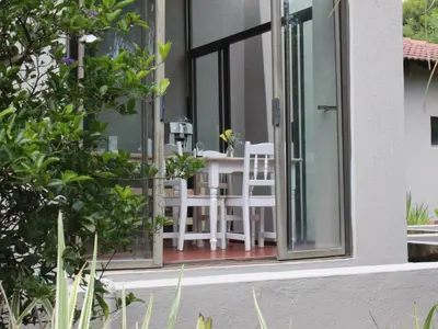 a patio with white chairs and a table in a window at Ambience Inn in White River