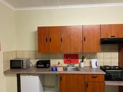 a kitchen with wooden cabinets and a counter top at The Royal Nest in Sandown