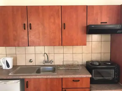 a kitchen with a sink and a stove and cabinets at The Royal Nest in Sandown