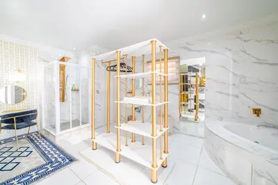 a bathroom with a tub and a toilet and a shelf at Homes of Ace Diamond in Pretoria