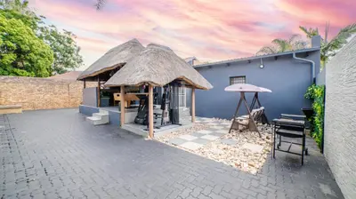 a blue building with a thatch roof at Homes of Ace Diamond in Pretoria