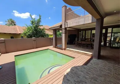 a house with a swimming pool on a wooden deck at 10 Pecanwood Dr 4 Bedroom Beauty in Hartbeespoort