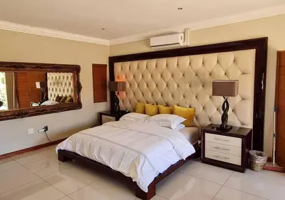 a bedroom with a large bed and a large mirror at 10 Pecanwood Dr 4 Bedroom Beauty in Hartbeespoort