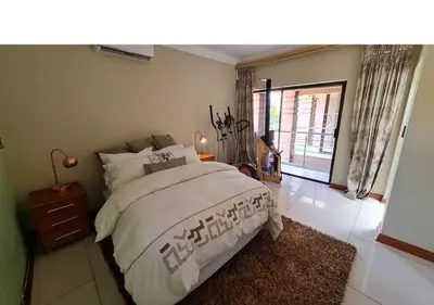 a bedroom with a large bed and a window at 10 Pecanwood Dr 4 Bedroom Beauty in Hartbeespoort