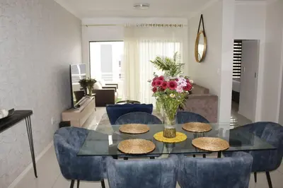 a dining room table with chairs and a vase of flowers at Chic Home in Erand