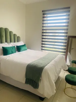 a bedroom with a large white bed and a window at Chic Home in Erand