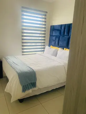 a large bed with a blue headboard in a bedroom at Chic Home in Erand
