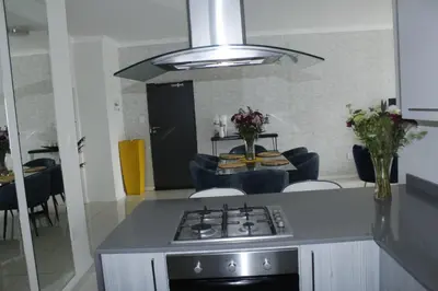 a kitchen with a stove and a table with chairs at Chic Home in Erand
