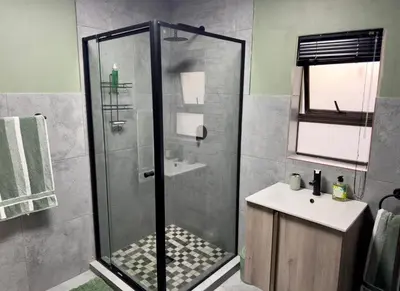 a bathroom with a shower and a sink at Wild Fig Rest Guest House in Polokwane
