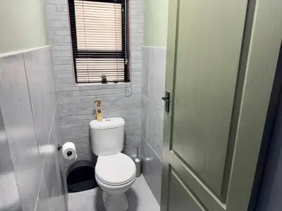 a small bathroom with a toilet and a window at Wild Fig Rest Guest House in Polokwane