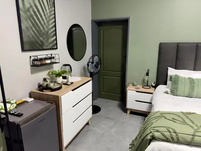a bedroom with a bed and a dresser and a mirror at Wild Fig Rest Guest House in Polokwane