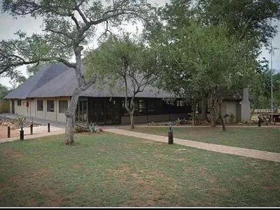 a building with a tree in the middle of a yard at Kubu Bush Lodge in Hoedspruit