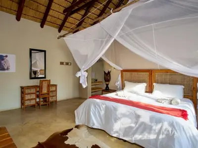 a bedroom with a large bed with a canopy at Kubu Bush Lodge in Hoedspruit