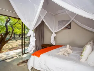 a bedroom with a bed with a canopy at Kubu Bush Lodge in Hoedspruit