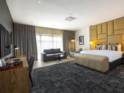 a large hotel room with a large bed and a couch at Panorama Villa in Graskop