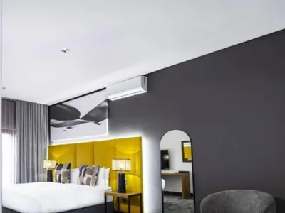 a bedroom with a large bed and a yellow wall at Panorama Villa in Graskop